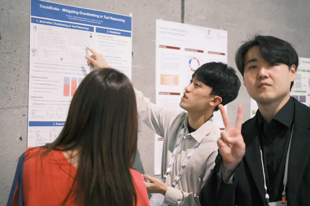 Researchers discussing a poster at NeurIPS 2025